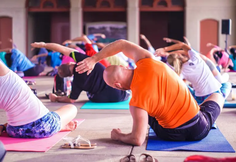 a group of people doing yoga in a gym.