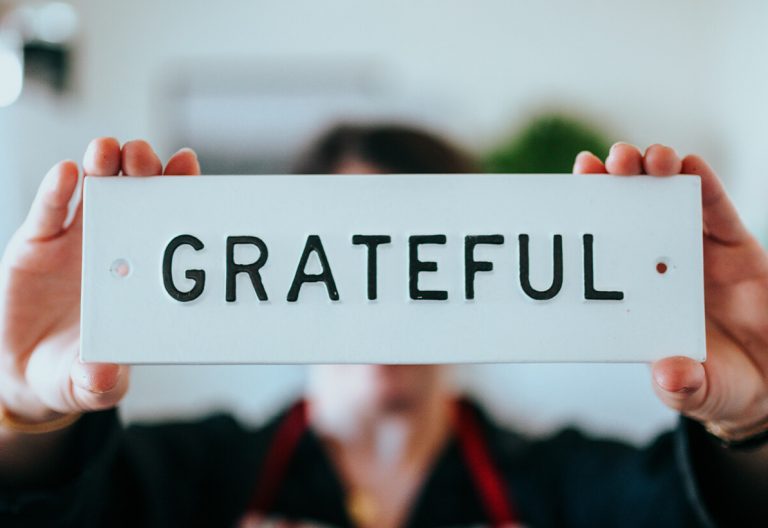 a woman holding up a sign that says grateful.