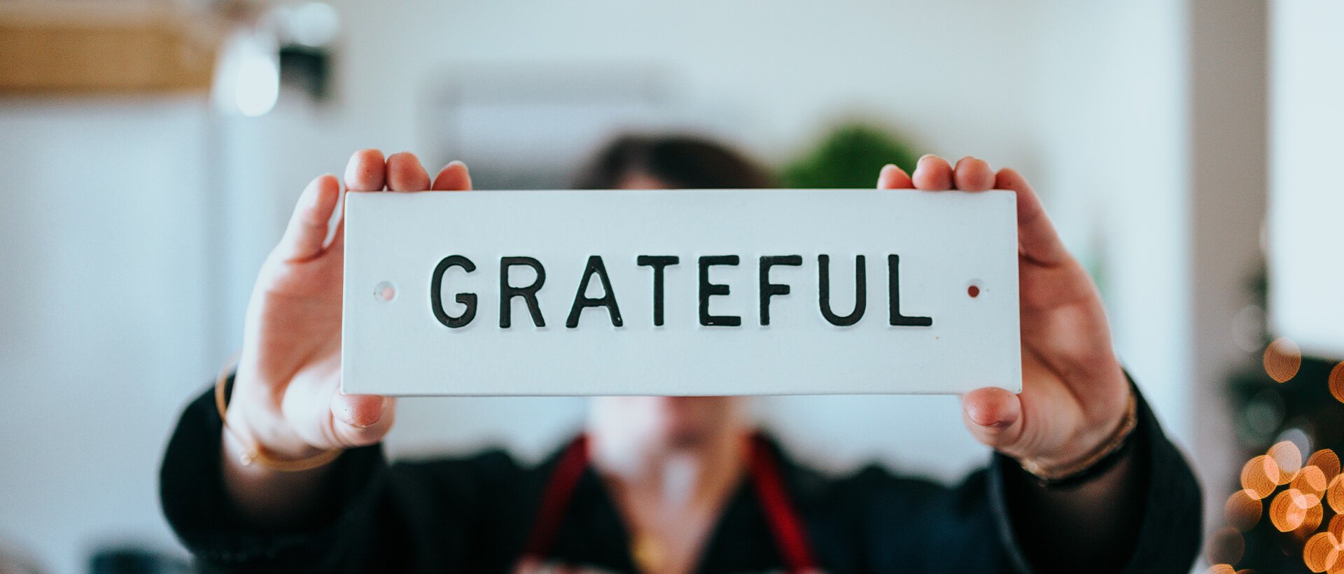 a woman holding up a sign that says grateful.