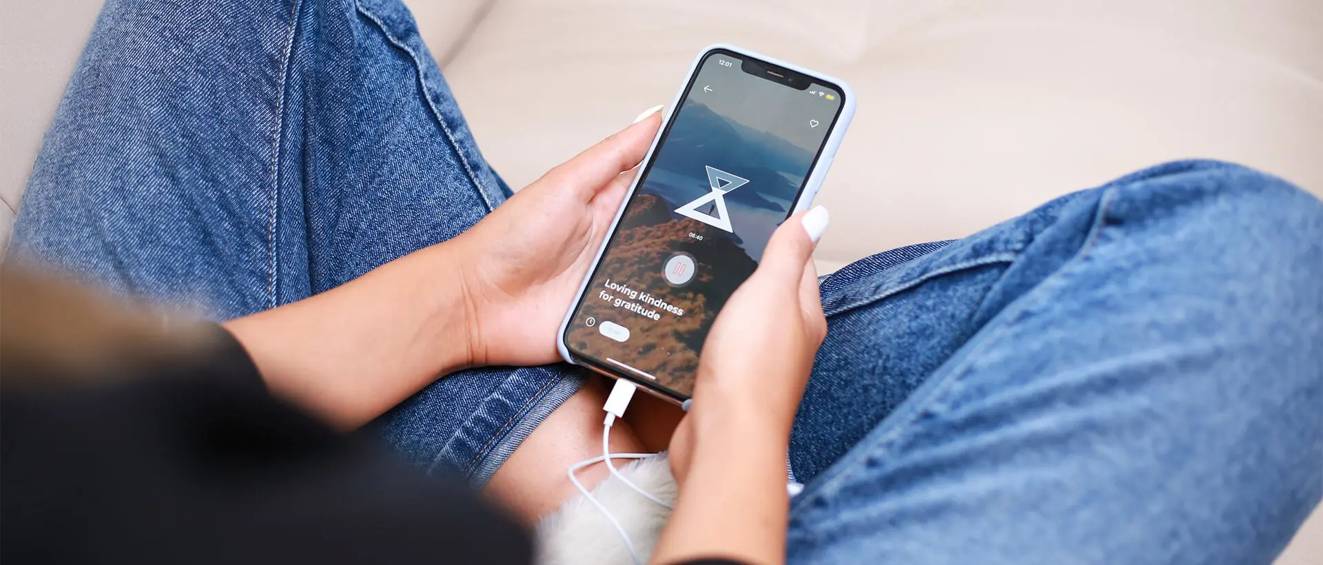 a person sitting on a couch holding a cell phone.