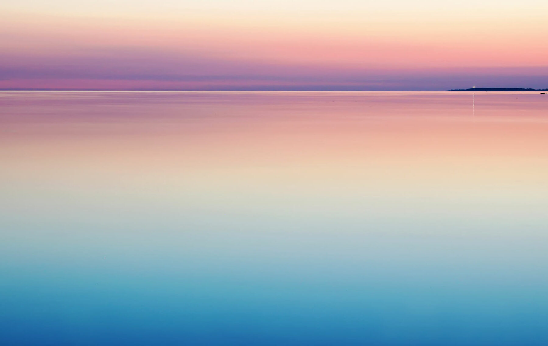 a large body of water with a boat in the distance.