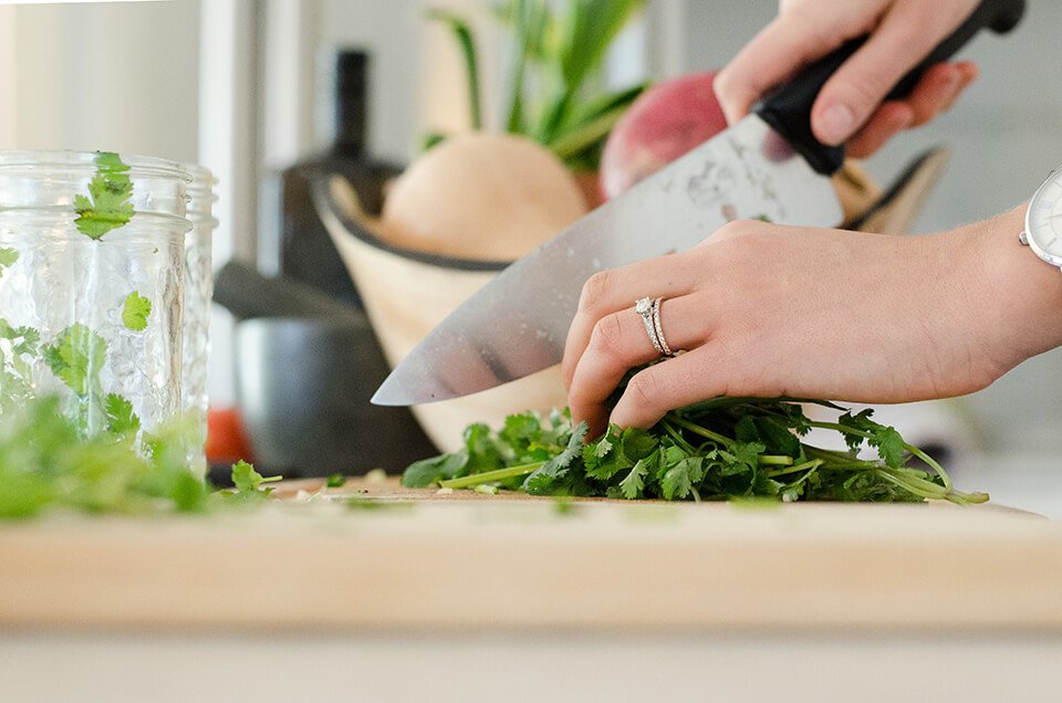 Woman chopping vegetables on cutting board