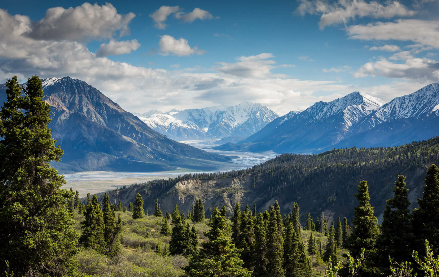 a scenic view of a valley with mountains in the background.