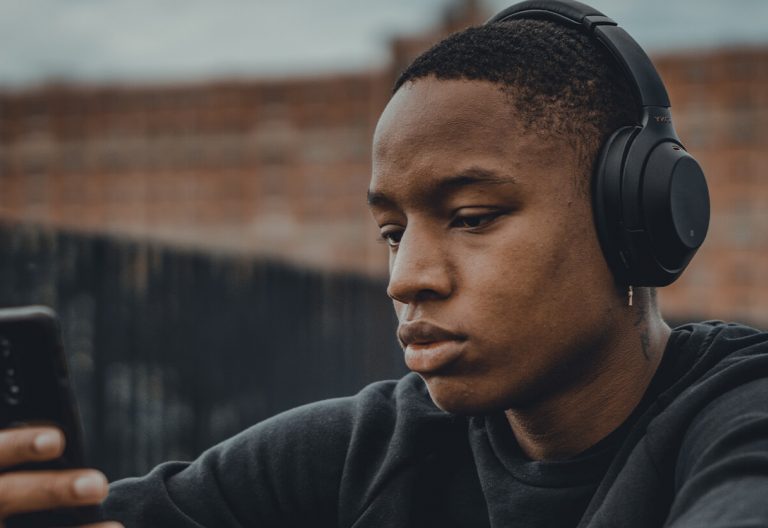 a man wearing headphones looking at his phone.