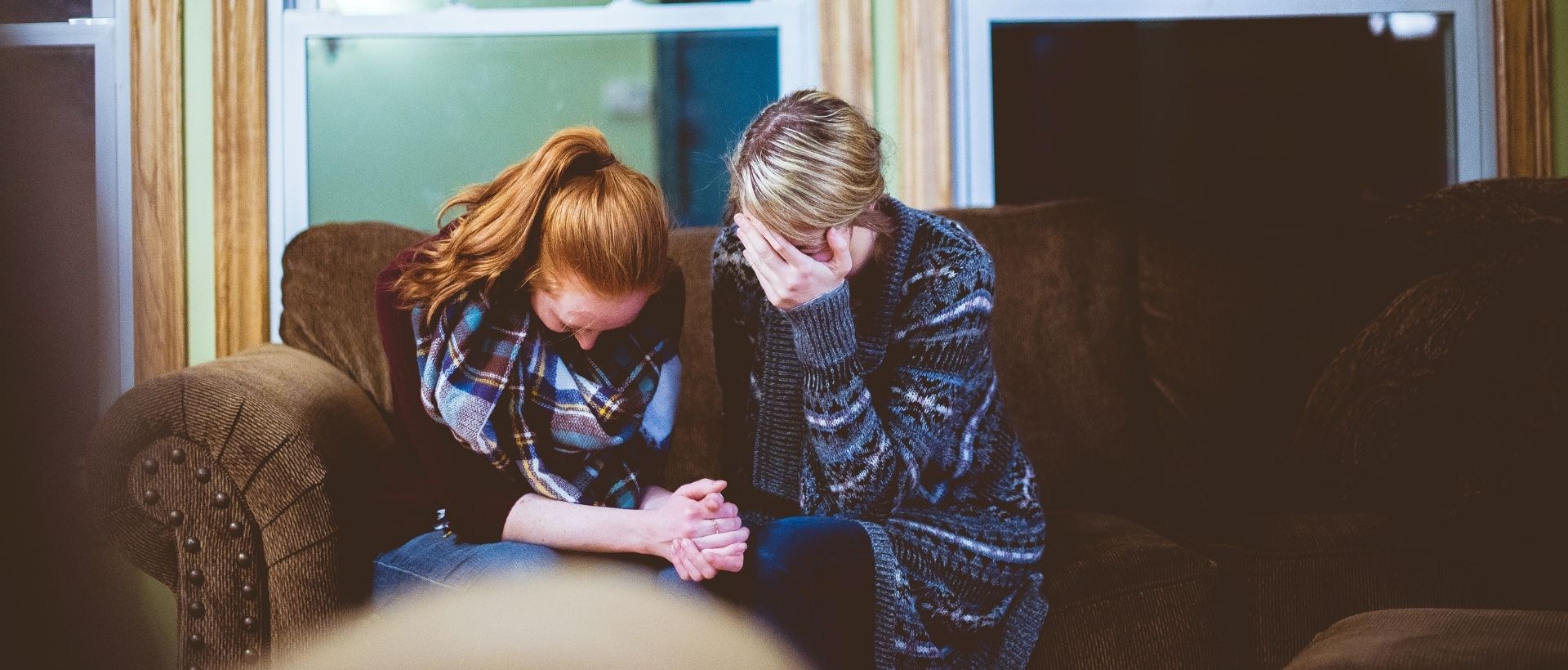 a couple of women sitting on top of a couch.