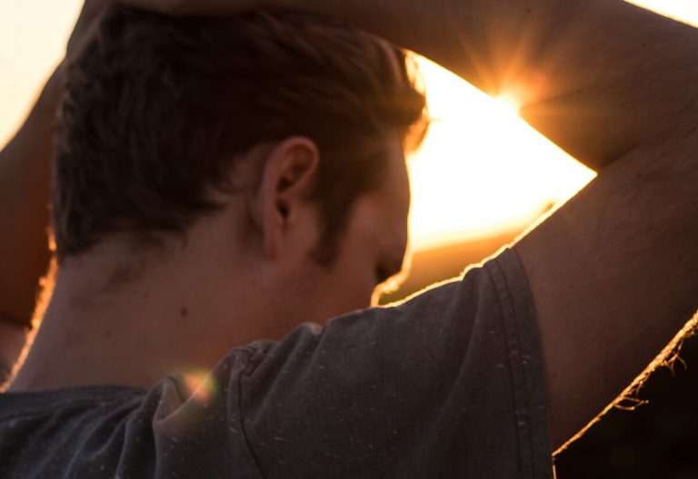 a man holding his hands up to his head.