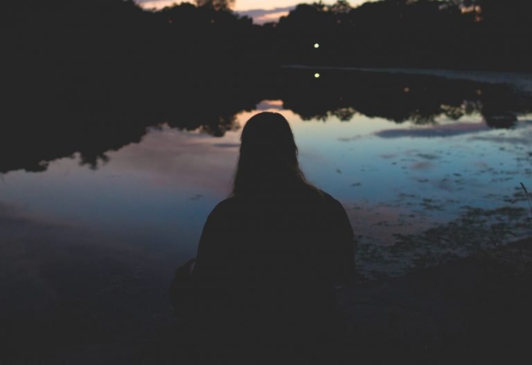 a person standing in front of a body of water.