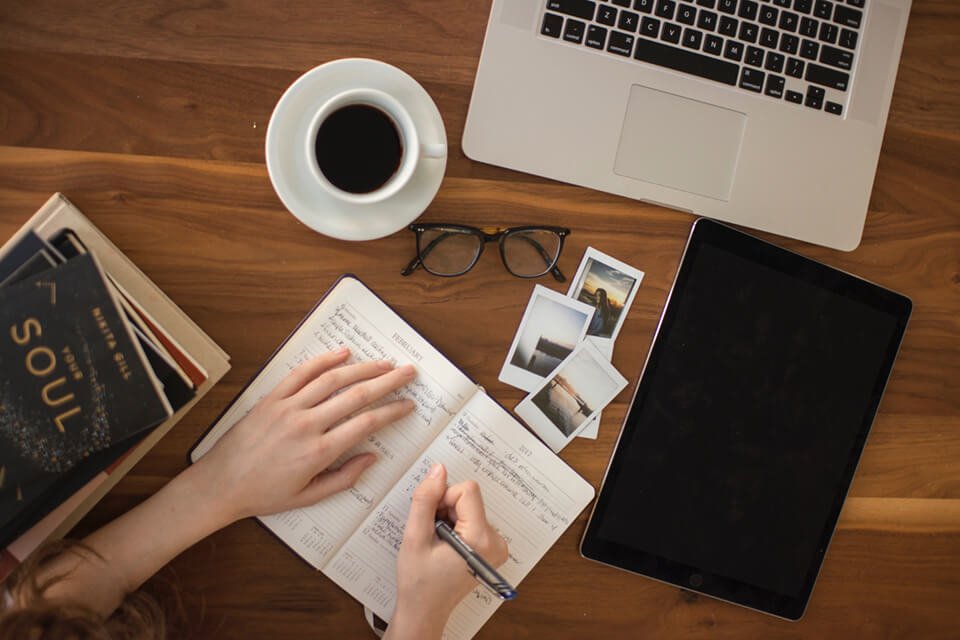 Woman writing diary into her notebook