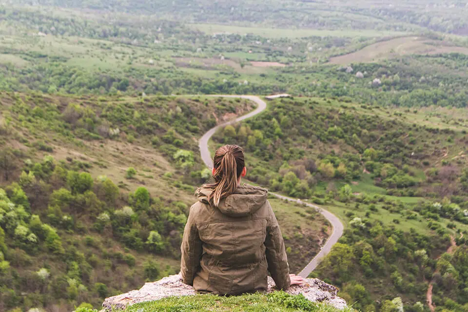 Woman looking at path, reflecting on journey