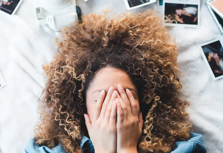 a woman covering her face with her hands.