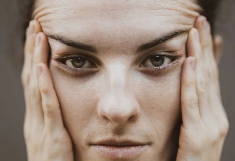 a woman holding her hands to her face.