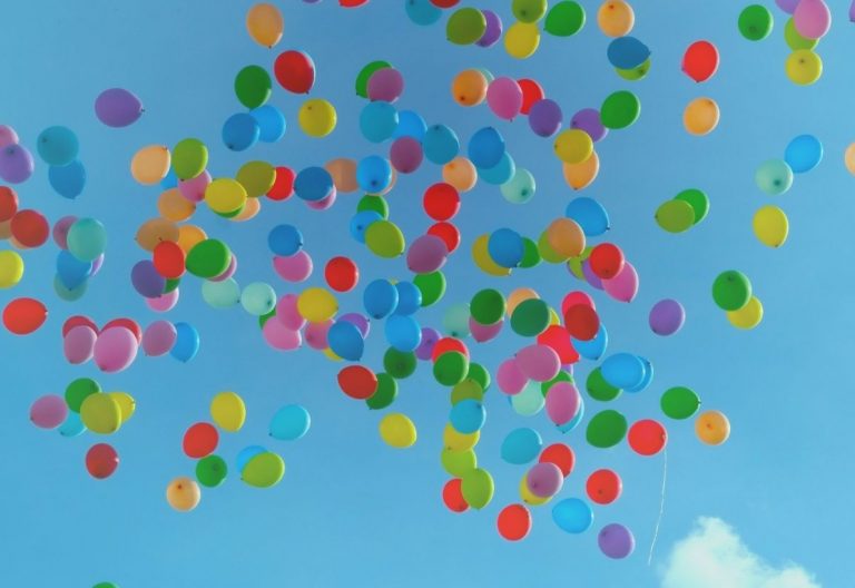 a bunch of balloons floating in the air.