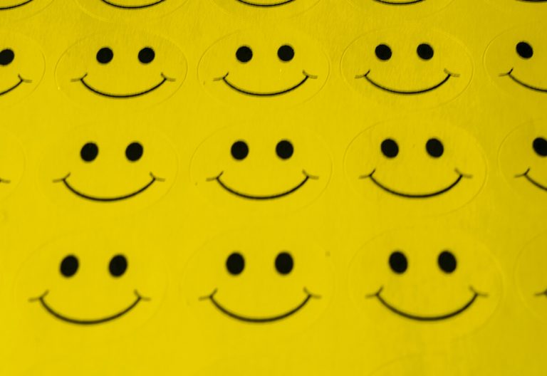 a group of smiley faces on a yellow background.