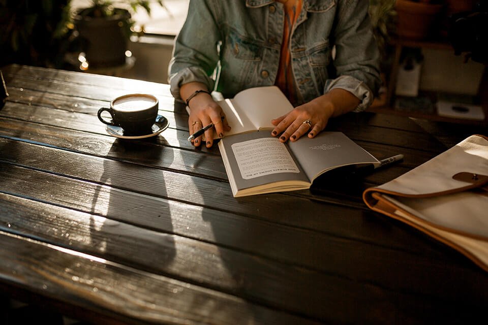 Woman writing into a gratitude journal