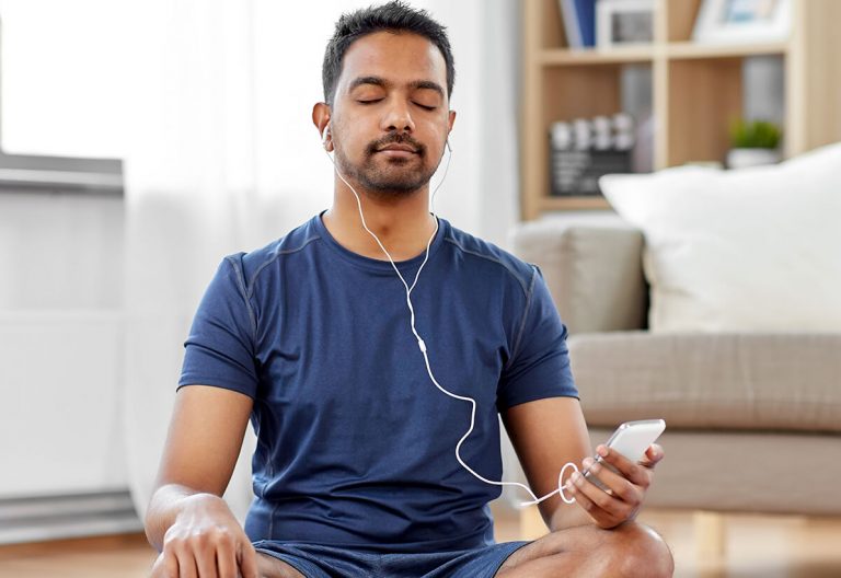 a man sitting on the floor listening to music.