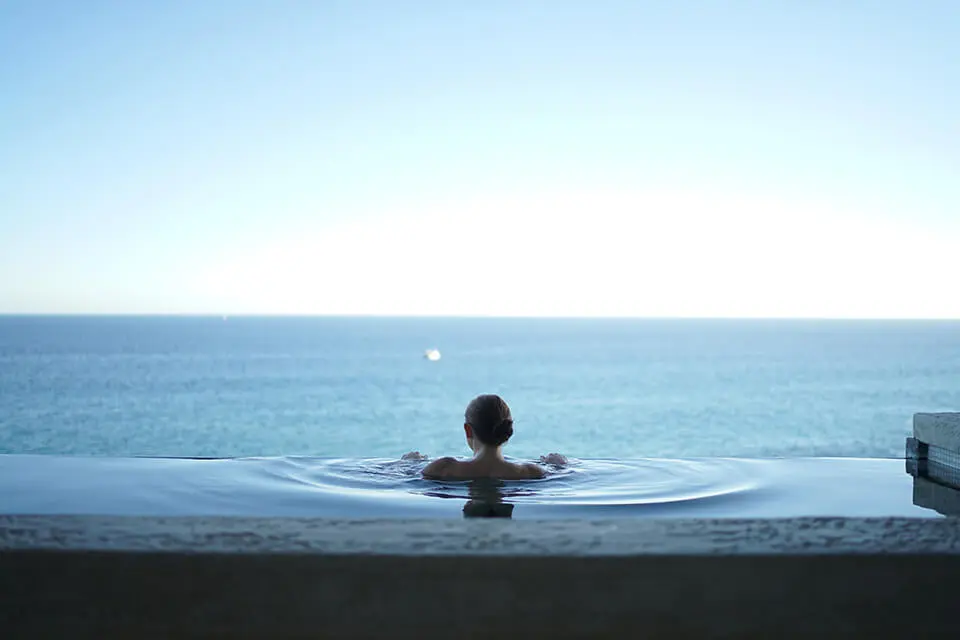 Woman in edgeless pool achieving inner peace