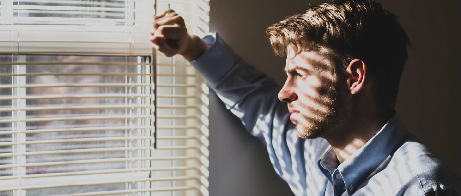 a man is looking out of a window.