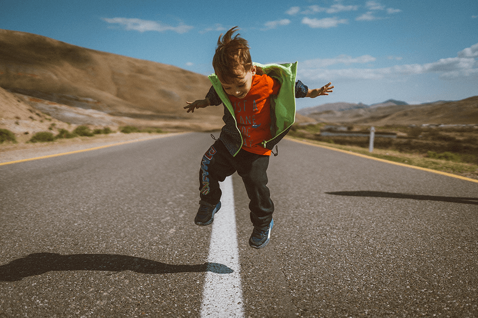 Child jumping up and down on the street