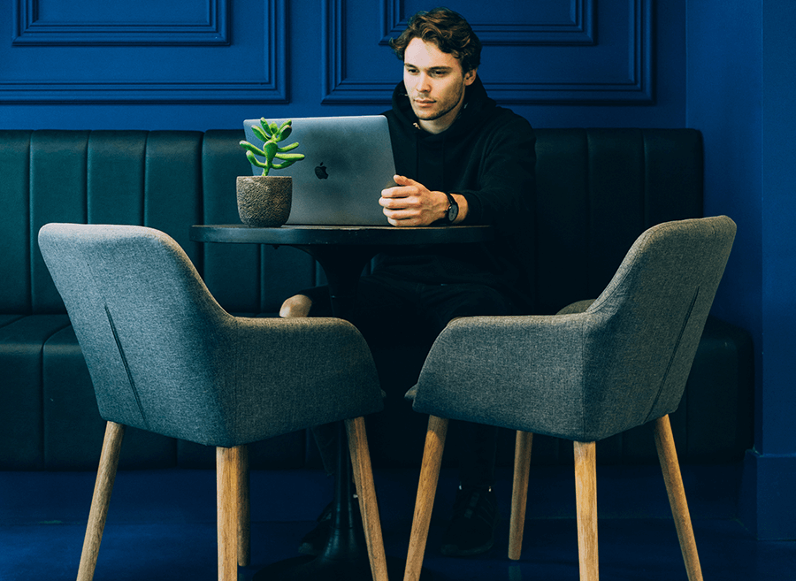 man working on laptop in corner of room