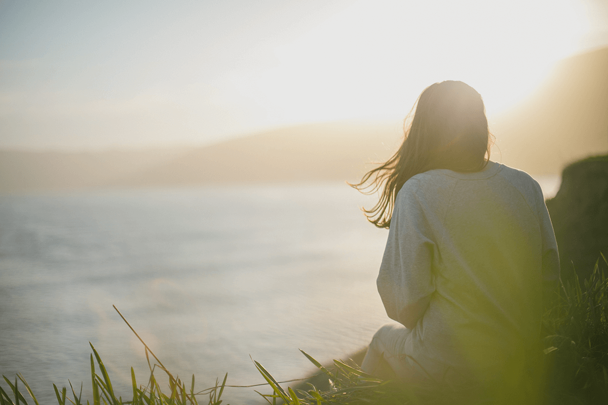 Woman sitting outside practicing meditation