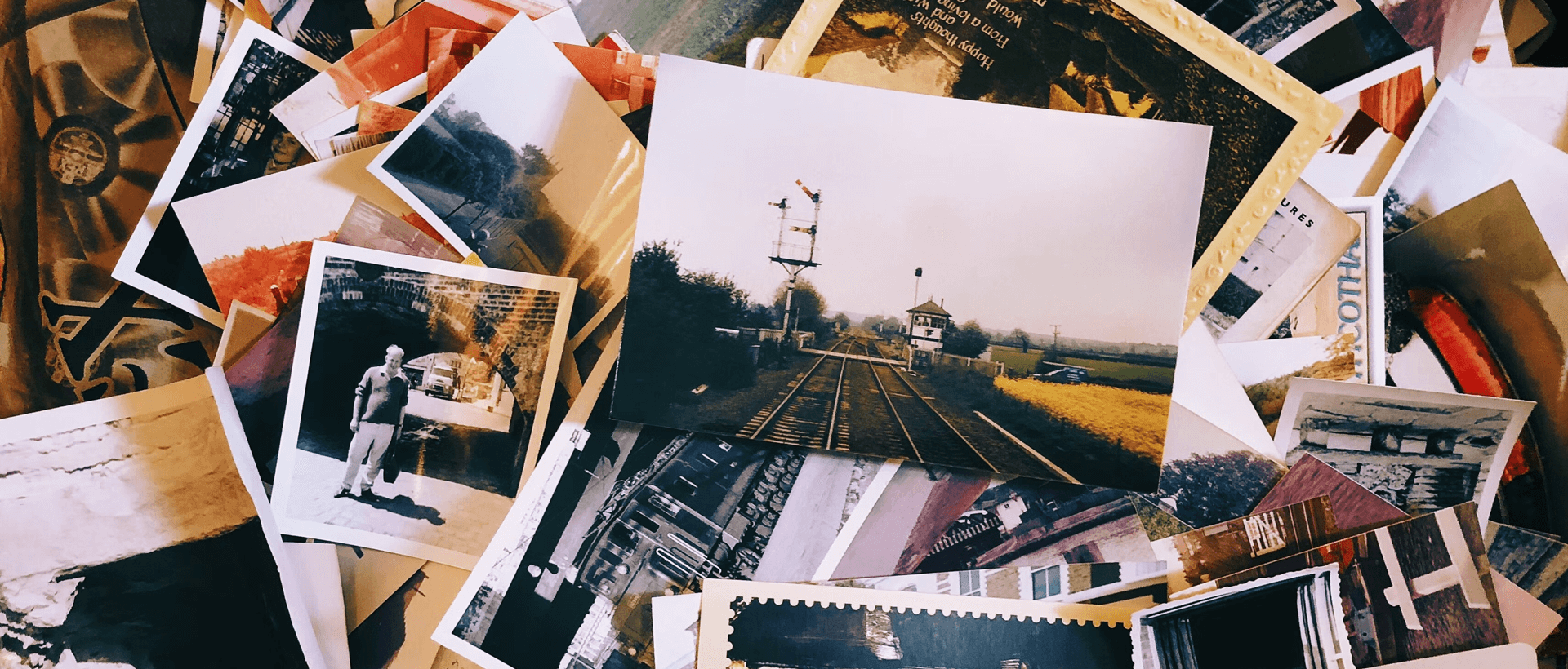 a pile of old photos and postcards sitting on top of a table.