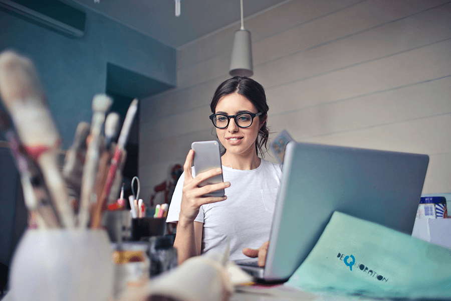 woman on phone while working on laptop